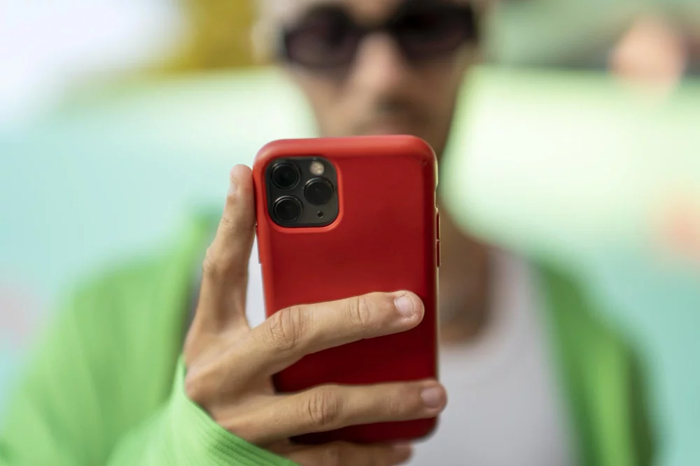 Como obter seguidores no Instagram? 5 selective focus person looking smartphone red case